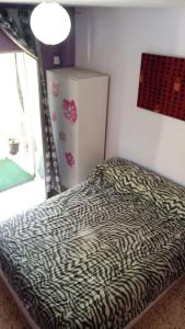ein Bett mit Zebramuster in einem Zimmer mit Fenster in der Unterkunft piso completo. in San Vicente del Raspeig