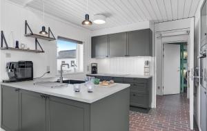 uma cozinha com armários cinzentos e um balcão branco em Beautiful Home In Pandrup With Wifi em Pandrup