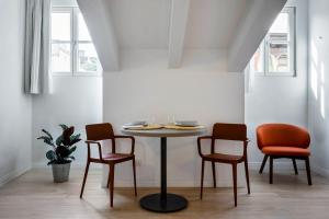 einen Tisch und drei Stühle in einem Zimmer in der Unterkunft DOMO Premium Apartments - Trieste Mazzini in Triest