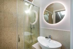 W łazience znajduje się umywalka i przeszklony prysznic. w obiekcie DOMO Premium Apartments - Trieste Mazzini w Trieście