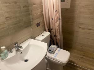 a bathroom with a white sink and a toilet at Modern, ideally located studio apartment in Athens