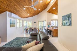 a living room with a couch and a dining room at The Birubi Beach House 11 Campbell Ave Close to the beach pet friendly holiday home in Anna Bay