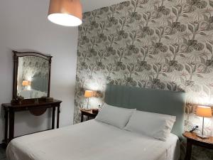 1 dormitorio con cama y pared con papel pintado en La Casa de Mami II, en Tanque