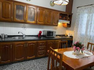 cocina con mesa, fregadero y microondas en La Casa de Mami II, en Tanque