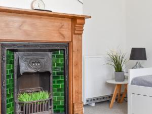 a fireplace with green tile in a room at High Street Apartment in Kessingland