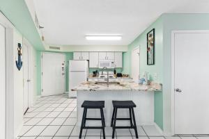 eine Küche mit zwei Hockern an einer Küchentheke in der Unterkunft Harbor Place 206 in Gulf Shores + 33 Fotos