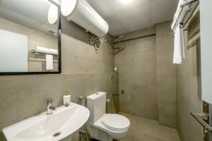 a bathroom with a white toilet and a sink at Olive Indiranagar - By Embassy Group in Bangalore