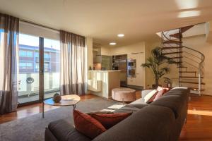 a living room with a couch and a spiral staircase at AR Prestige Penthouse - Soho in Bergamo