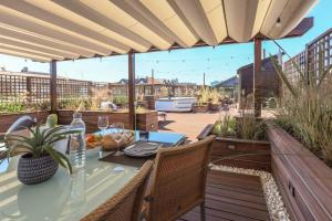 patio con tavolo e sedie su una terrazza di AR Prestige Penthouse - Soho a Bergamo