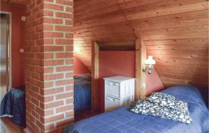 a bedroom with a bed and a brick wall at 2 Bedroom Awesome Home In Abbekås in Abbekås