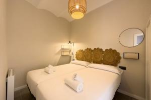 1 dormitorio con 1 cama blanca grande y 2 toallas en New 2 bedroom apartment in Plaza España, en Barcelona
