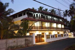 a large house with a balcony on top of it at Cherai Beach view Heritage in Pallipuram