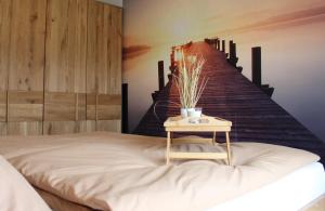 a bedroom with a bed with a table next to a staircase at Apartment Blicksüd in Unterburg am Klopeiner See