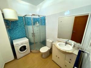 a bathroom with a toilet sink and a washing machine at ALCAMAR Alquiler de Habitaciones con cocina y baño compartido y balcón con vista al mar! in Alcalá