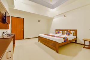 a bedroom with a bed and a tv and a table at FabHotel Shivam, Karelibagh in Vadodara