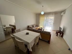 a living room with a table and a couch at Comfort 1 Apartment in Sarandë