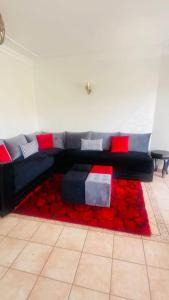 a couch in a living room with a red rug at Lovely 2 bedrooms appartment with rooftop in Temara