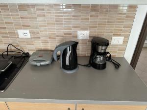 a counter top with a coffee maker and a blender at Comfort 1 Apartment in Sarandë