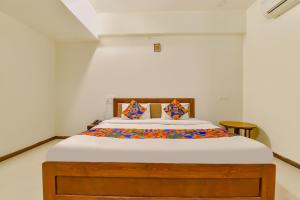 ヴァドーダラーにあるFabHotel Shivam, Karelibaghのベッドルーム1室(カラフルなシーツを使用した大型ベッド1台付)