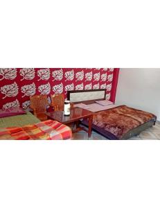 um quarto com uma mesa e duas cadeiras e uma mesa e um sofá em Hotel Omkar & Restaurant, Uttarkashi em Uttarkāshi