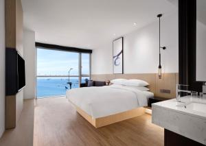 a bedroom with a bed and a view of the ocean at Fairfield by Marriott Busan Songdo Beach in Busan