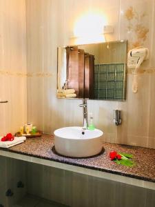 uma casa de banho com um lavatório branco e um espelho. em Villa Source D'Argent em La Digue