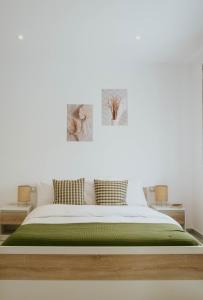 a bedroom with a white bed with green sheets at Kaliva Residence in Kalamaki
