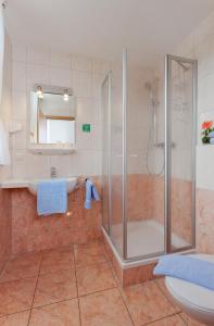 a bathroom with a shower and a sink and a toilet at Strandhotel Sanddorn in Trassenheide