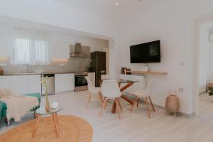 a living room with a table and chairs and a kitchen at Kaliva Residence in Kalamaki