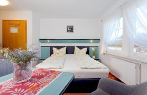 a bedroom with a bed with a vase of flowers at Strandhotel Sanddorn in Trassenheide