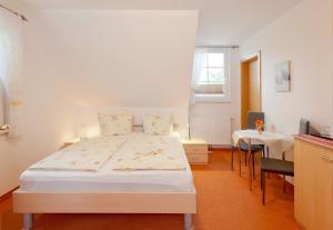 a bedroom with a bed and a table with chairs at Strandhotel Sanddorn in Trassenheide