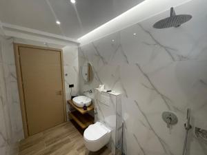 a white bathroom with a toilet and a sink at Luxury Sea View Apartaments in Sarandë +220 photos