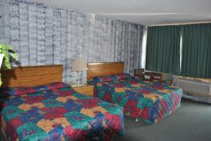 ein Hotelzimmer mit 2 Betten und einem Fenster in der Unterkunft Travel Inn Motel Michigan City in Michigan City