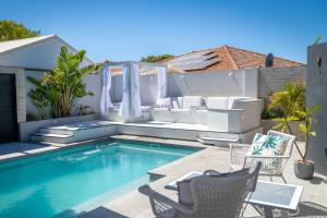 a backyard with a swimming pool with chairs and a patio at Mindarie Retreat in Mindarie