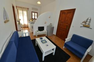un soggiorno con un divano blu e un tavolo di Anofli Suites a Skopelos Town