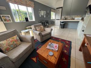 a living room with two couches and a coffee table at PIGEONWOOD Forest Cottage in Ballito