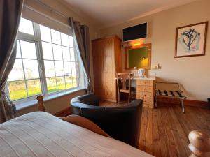 een slaapkamer met een bed, een bureau en een raam bij St Martin's, Rosslare Harbour Guest Accommodation in Rosslare