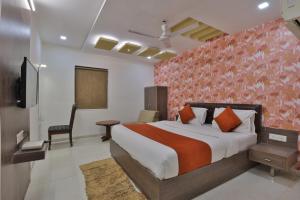 a hotel room with a bed and a tv at Hotel Sadbhav in Ahmedabad