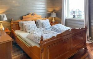 a bedroom with a wooden bed with white sheets and pillows at Beautiful Home In Stryn With Kitchen in Stryn +17 photos