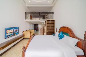 a bedroom with a bed and a tv at April Fair Duplex Apartment Guagnzhou South Railway Station Min Jie Branch in Guangzhou