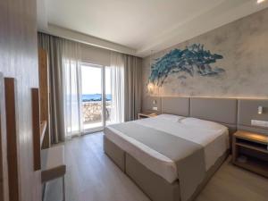 a bedroom with a large bed and a large window at Hotel Rex in Livorno