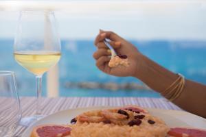 a person eating food on a table with a glass of wine at Hotel Rex in Livorno