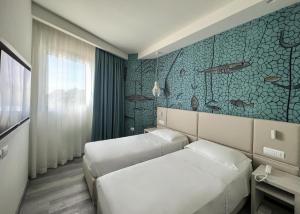 a bedroom with two beds and a wall with fishes at Hotel Rex in Livorno