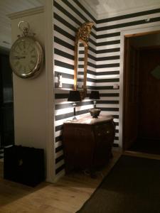une chambre avec une horloge et une table avec une lampe dans l'établissement Lovely home in Inkoo by the sea, à Inkoo