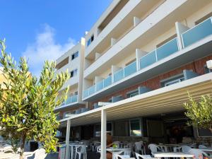 an exterior view of a hotel with tables and chairs at Hotel Rex in Livorno