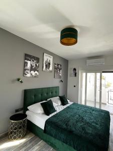 LuxVilla AURORA في فوديس: غرفة نوم مع سرير مع اللوح الأمامي الأخضر