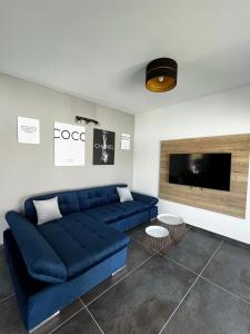 a living room with a blue couch and a tv at LuxVilla AURORA in Vodice
