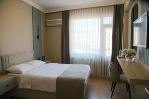 ein Hotelzimmer mit einem Bett, einem Schreibtisch und einem Fenster in der Unterkunft Otel 57 in Sinop