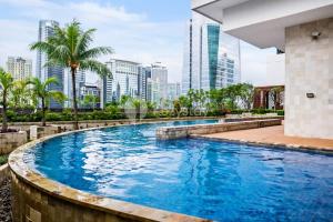 a swimming pool with a city skyline in the background at Sattva by Kozystay - Next to Mall in Jakarta