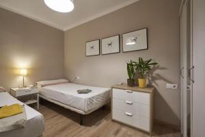 a bedroom with two beds and a table with a plant at Ideal 3 bedroom apartment in Sant Andreu in Barcelona